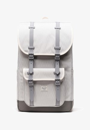 Gray quilted fabric backpack with a flap closure, featuring gray straps and a white trim. Includes a front logo tag and reinforced bottom.