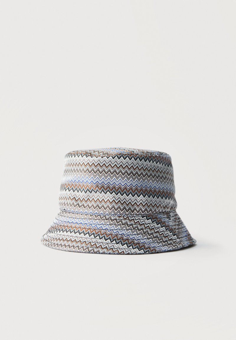 Κασκέτο με ζιγκ-ζαγκ μοτίβο σε αποχρώσεις καφέ, μαύρου, λευκού και μπλε πάνω σε απλό λευκό φόντο.