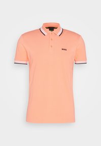 Polo en tissu pêche doux, avec un col rayé bleu marine et blanc, trois boutons, et un logo "BOSS" brodé sur la poitrine.