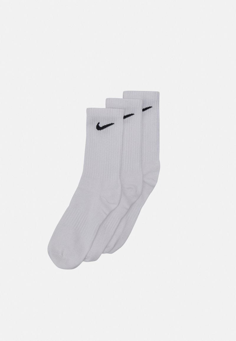 Hvite bomull crew sokker i et sett av tre, med ribbet tekstur og svart Nike-logo på toppen.