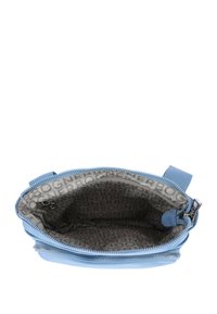 Borsa a mano in tessuto blu con chiusura a zip. All'interno presenta un rivestimento grigio chiaro con un motivo a logo ripetuto e una piccola tasca con zip.