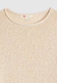 Εκρού πλεκτό πουλόβερ με στρογγυλή λαιμόκοψη και μικρή ετικέτα Levi’s με ένδειξη μικρού μεγέθους στο εσωτερικό της λαιμόκοψης.