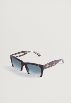 Ochelari de soare în tip tortoise cu un design rectangular îndrăzneț, lentile în gradient și accente portocalii contrastante pe brațe. Numele brandului "Moschino" este prezent.