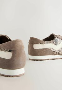 Braune Wildledersneaker mit Schlangenhautmuster, weißen Akzenten und strukturierten Gummisohlen. Die Rückansicht hebt Designdetails und Farbk kontraste hervor.