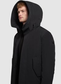 Parka neagră căptușită cu glugă mare, țesătură texturată, buzunare laterale și fermoar ascuns. Designul este elegant și modern.