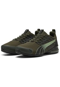 Zapatillas deportivas verde oliva con parte superior de malla, acentos negros y suela texturizada. Presentan detalles reflectantes y un collar acolchado para mayor comodidad.