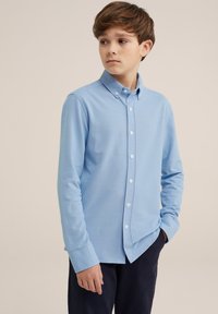 Cămașă cu mânecă lungă, în nuanță de albastru deschis, cu guler. Are un material texturat și nasturi albi. Croială relaxed, purtată cu pantaloni închiși la culoare.