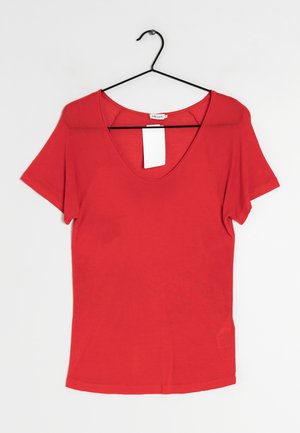 Rood T-shirt met korte mouwen en V-hals, hangend aan een zwarte metalen hanger tegen een witte achtergrond met een wit label in de kraag.