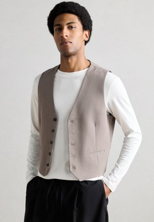 Šedá látková vesta s pěti knoflíky, nošená přes bílou košili s dlouhým rukávem. Má elegantní design a jednu boční kapsu.