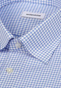 Koszula zapinana na guziki w jasnoniebieską i białą kratę, z klasycznym kołnierzykiem, miękką teksturą oraz metką seidensticker wewnątrz.