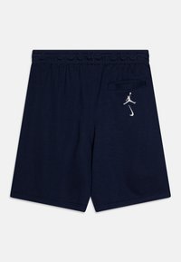 Navy shorts with an elastic waistband, featuring a rear pocket and white embroidered Jumpman logo on the left side. Smooth cotton blend fabric.