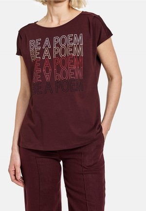 Bordeauxrode katoenen T-shirt met korte mouwen. Voorzijde met kleurrijke tekst "BE A POEM" in verschillende lettertypen en maten. Glad oppervlak.
