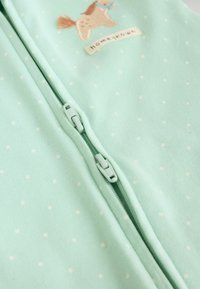 heleroheline kangas väikeste valgete täppidega, millel on topelt tõmblukk ning tikitud hobune ja tekst "homegrown".