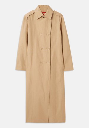 Manteau beige avec un devant croisé, des accents de bouton et un col. Présente de longues manches et une silhouette droite. Texture lisse.
