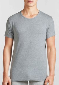 T-shirt grigio a maniche corte in un morbido e liscio tessuto. Presenta un classico scollo rotondo e una vestibilità rilassata con un orlo dritto.
