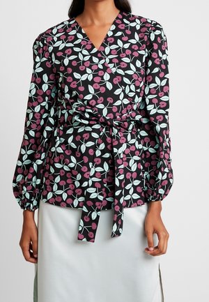 Blouse noire à enfiler avec un motif cerise et feuilles en rose et bleu clair, avec de longues manches bouffantes et un détail de taille nouée.