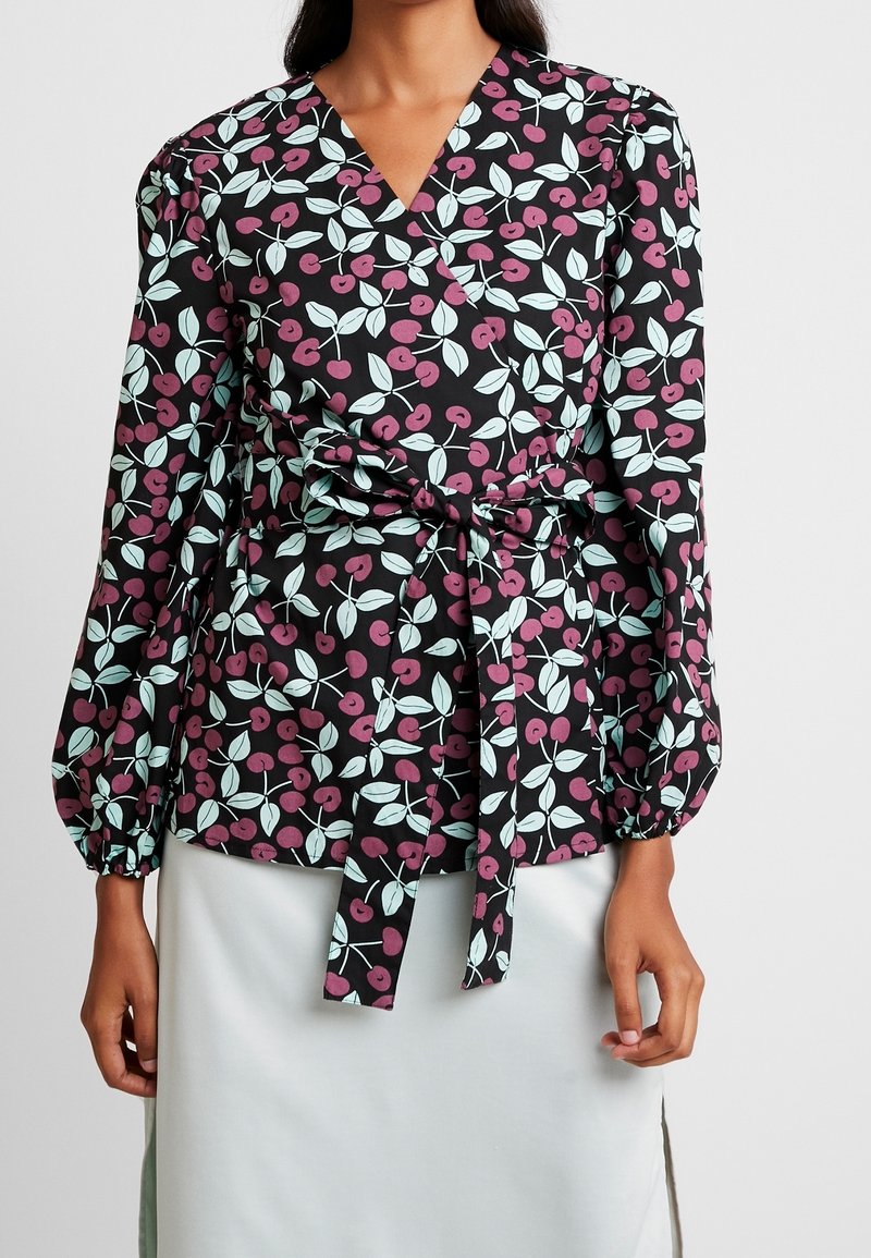 Blusa nera avvolgente con un motivo di ciliegie e foglie in rosa e blu chiaro, maniche lunghe a sbuffo e dettaglio in vita con nodo.