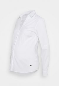 Camisa branca de mangas longas com colarinho, botões à frente e um detalhe circular de lado, feita de tecido suave.