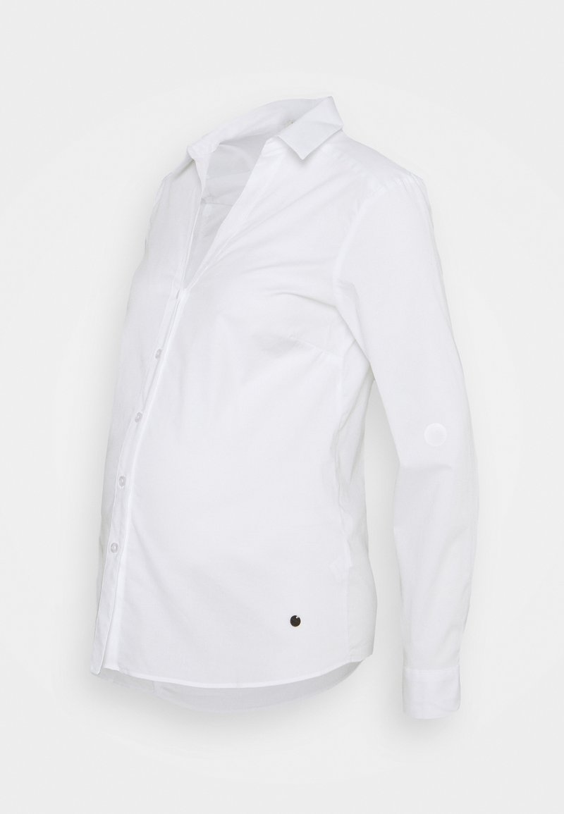 Camisa branca de mangas longas com colarinho, botões à frente e um detalhe circular de lado, feita de tecido suave.