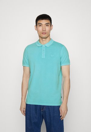 Polo shirt turchese realizzato in cotone, caratterizzato da un'apertura con bottoni e un dettaglio del logo sul petto. Maniche corte e design del colletto classico.