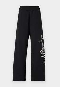Sorte joggebukser med vide ben, elastisk midje, side-lommer og en hvit grafisk design langs venstre ben. Laget av myk stoff.