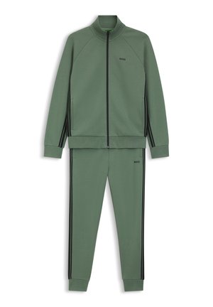 Zelená tepláková súprava z hladkej tkaniny, ktorá obsahuje bundu na zips s čiernymi pruhmi a zodpovedajúce nohavice; elegantný dizajn s rebrovanými manžetami.