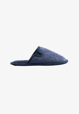 Pantufla de tela azul oscuro con una textura suave, punta redondeada y parte trasera abierta. Presenta un borde de un tono más oscuro en los contornos.