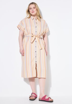Vestido de botones a rayas en colores pastel con mangas cortas, un lazo en la cintura y una falda larga. Combinado con sandalias rosas con borde festoneado.