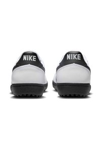 Bijele i crne Nike tenisice s teksturiranom kožnom gornjištem, crnim leđnim potporom i crnim gumenenim potplatom s oblikovanim trakama za prianjanje.