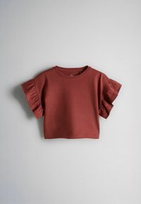 Krátky crop top s krátkym rukávom v červeno-hnedej farbe s volánikmi na rukávoch a okrúhlym výstrihom, položený na svetlosivom pozadí.