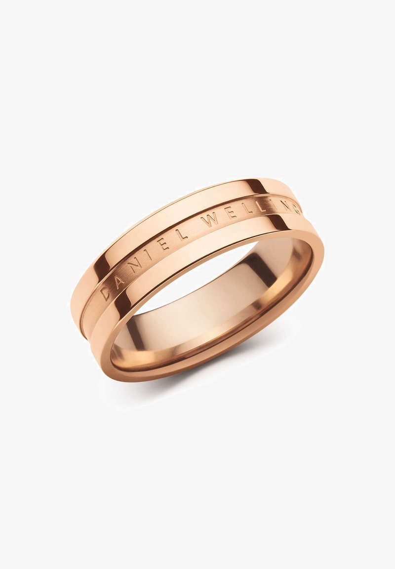 Ruusukultainen sormus, jossa on kaksi nauhaa; yksi kiillotettu ja toinen kaiverrettu "DANIEL WELLINGTON". Sujuva pinta, jossa on tyylikäs ja moderni muotoilu.
