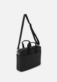 Schwarze Laptop-Tasche mit glatter Außenseite, zwei kurzen Griffen und einem verstellbaren Schultergurt. Verfügt über einen oberen Reißverschluss und eine Fronttasche.