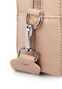 Kout kožené tašky v béžové barvě s lesklými stříbrnými kovovými doplňky, obsahující zip a klipový úchyt, s viditelným švem a texturou.