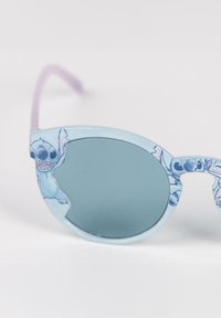 Occhiali da sole a forma di occhio di gatto con una montatura azzurro chiaro, caratterizzati da un design in stile cartone animato di un personaggio, e lenti riflettenti verdi con aste viola.