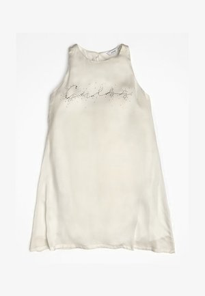 Bez rękawów, kremowa sukienka wykonana z gładkiej tkaniny o lekko prześwitującym wykończeniu. Na przodzie ozdobiona kryształkami i wzorem tekstowym.