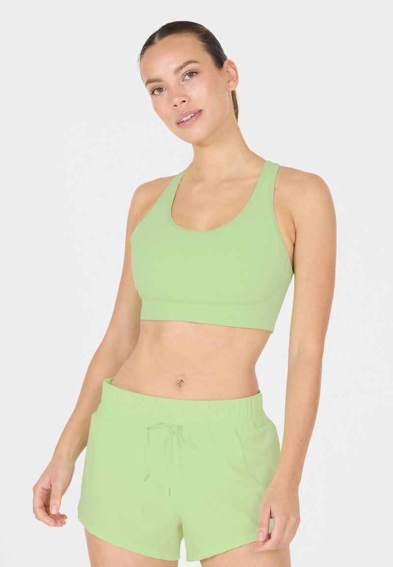 Ljusgrön sport-bh och matchande shorts i elastiskt material, med en figursydd design och ett elastiskt midjeband med dragsko.