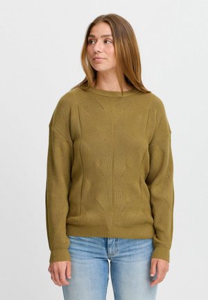 Pull en maille vert olive avec motif texturé et col rond. Manches longues avec bords côtelés. Associé à un jean bleu clair.