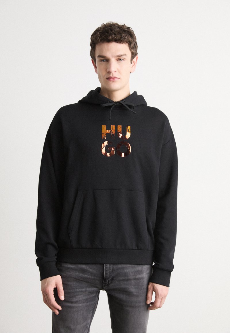Sudadera negra con capucha que presenta un bolsillo frontal y un logotipo abstracto en tonos naranjas y marrones. Hecha de tela suave con puños y dobladillo acanalados.