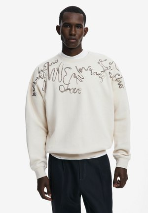 Light cream sweatshirt with cursive text embroidery in dark brown. Features a crew neck, long sleeves, and relaxed fit.
