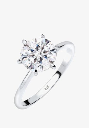 Sterling silver ring with a round, clear cubic zirconia centerpiece held by six prongs; polished band features a "925" hallmark.