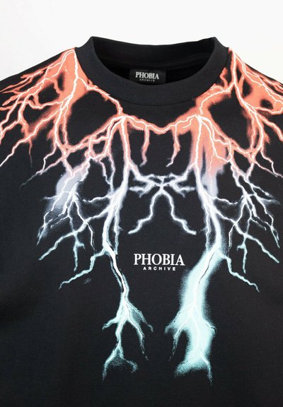 Maglietta nera con grafica di un fulmine in rosso e blu. Logo "PHOBIA ARCHIVE" stampato in bianco al centro in basso. Design con collo rotondo.