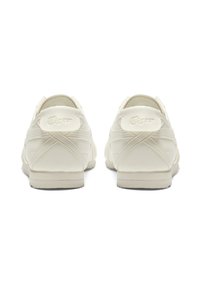 Krämfärgade sneakers med en slät läderovandel, förstärkta sömmar och en texturerad gummisula. Har logotypdetalj på hälen.