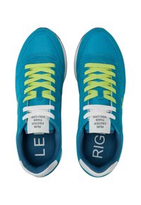Scarpe da ginnastica turchesi brillanti con lacci verde lime a contrasto, dotate di una parte superiore texture, soletta imbottita e suola in gomma bianca.