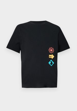 Camiseta de algodón negra con tres diseños gráficos coloridos: una flor roja, una flecha amarilla y un diamante turquesa con un motivo de ola.