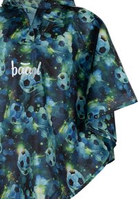 Poncho da pioggia blu e verde con un motivo esagonale, caratterizzato da grafiche di palloni da calcio e una chiusura frontale con bottoni. Il materiale è impermeabile.