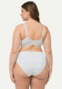 Soutien-gorge gris clair avec bretelles réglables et fermeture à crochet, associé à une culotte taille haute présentant un motif ondulé dans des couleurs pastel.