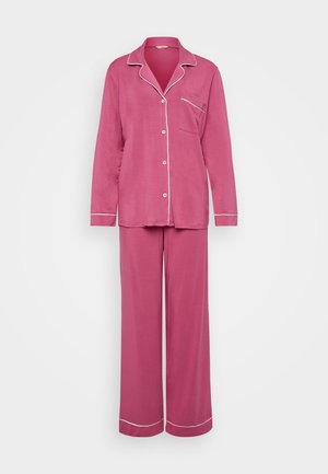Ensemble de pyjama en coton rose comprenant un haut à boutons avec une poche sur la poitrine, des passepoils blancs le long du col et du pantalon, ainsi que des pantalons amples.