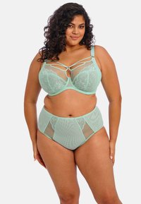 Conjunto de lencería verde menta que presenta un sujetador con detalles de encaje, paneles de malla y tirantes entrelazados, combinado con braguitas de malla de cintura alta.