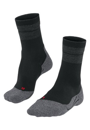 Chaussettes noires avec talons et orteils gris, présentant un design côtelé et des bandes supérieures contrastantes. Comprend un petit logo rouge sur le côté.