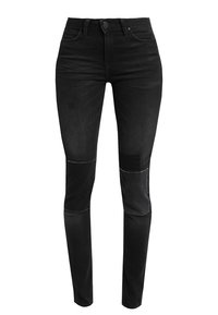 Jeans de denim negro con un diseño ajustado, que presentan parches en las rodillas y una textura sutil. Estilo clásico de cinco bolsillos con cierre de botón en el frente.